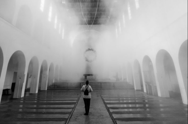 man in black jacket walking on hallway