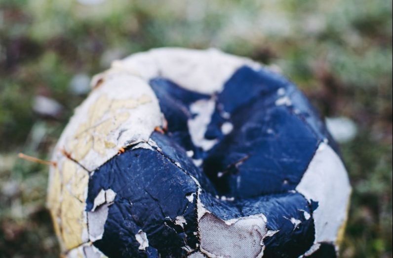 white and blue soccer ball on green grass field